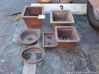 Lot of 6 ceramic bonsai planters arranged outside on concrete, viewed from above showing shape, sizes and condition.