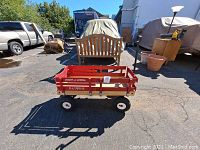Photo of the full Radio Flyer red wooden wagon with off-road wheels on asphalt surface, showing side profile