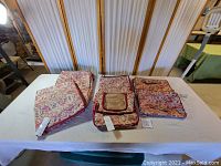All five floral camouflage storage bags arranged on table, showing various sizes and pattern