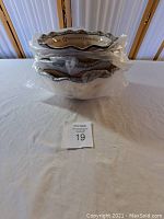 Stacked view of the three Temp-tations Holiday Old World ovenware bowls wrapped in plastic.