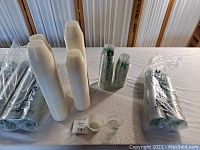 View of stacks of clear plastic food cups with some branded Dixie cups showing logo and text. SOLO branded cups seen in packaging.