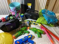 Full overview of the lot showing water guns, toys, goggles, boombox, cooler, floaters, pails and shovels, and Speedo board