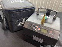 Front and side view of Lagenda electric balloon pump with carrying case nearby.