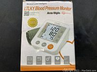 Photo showing LT LK Y blood pressure monitor packaging box with product image and branding details.