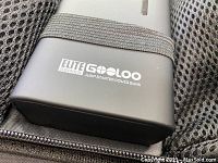 Close-up of GOOLOO Elite Series logo on jump starter power bank with elastic band strap on top