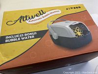 Box packaging of Attwell Automatic Bubble Machine showing brand, model AYWORN, and note about bonus bubble water