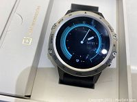 Close-up of Sanag digital watch with silver bezel and black strap showing the watch face and interface