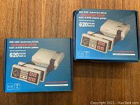Two boxed Mini Game Anniversary Edition systems with 620 built-in classic games displayed on their original blue packaging.