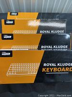 Four Royal Kludge keyboard boxes stacked, showing brand and model