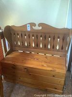 Full view of wood storage bench showing seat, backrest, and armrests