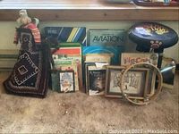 Full lot showing signed print, assorted books, glockenspiel, tambourine, tiger stool, and fabric doll.