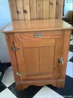 Front view showing oak wood panel door with brass hardware and a decorative brass plate labeled 'SANITARY'.