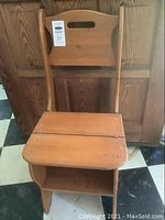 Full view of the wooden chair showing the backrest and seat with hinged design.