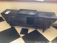 Full frontal view of the wooden jewel box showing three drawers and central door, tray, and detached door piece on floor