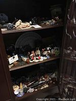 Three-tier wooden shelf filled with assorted small decorative objects