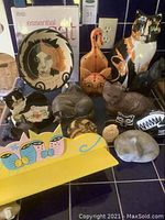 Wide view showing most items in lot including plate, figurines, wooden shelf, and vase.