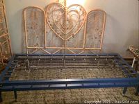 Folded blue metal bed frame with attached spring rods