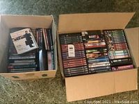 Two cardboard boxes filled with assorted DVDs in cases and boxed sets.