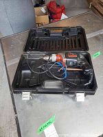 Hammer drill placed inside the black plastic carrying case showing cord and general condition
