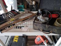View of two Stanley FatMax Xtreme metal levels alongside a metal toolbox with screws and a red Milwaukee electric saw in a black carrying case.