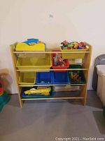 Front view of wooden toy organizer shelf with colorful plastic bins filled with assorted children's toys