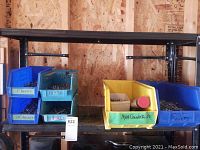 Organizer bins filled with screws and bolts on a metal shelving rack.