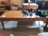View of wood coffee table with various electronics removed, showing table surface and turned legs.