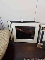 Three framed art pieces leaning against the wall.
