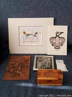 Full view of the five items including prints, copper art piece and carved box.