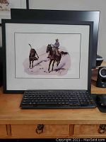 Two framed Fredric Remington cowboy prints shown with keyboard in front for size scale.