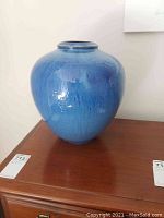 Front view of a heavy blue glazed ceramic vase, showing its color and shape.