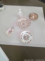 Overall view of all fine china items including Aynsley bud vase, footed bowl, Limoges dish, and Royal Crown Derby condiment dish set.