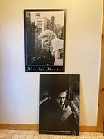 Frontal photo showing both Marilyn Monroe and James Dean black and white wood prints mounted on a wall.