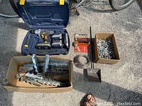 Full lot overview showing joist hangers, drill in case, as well as wire coil, shovel and sharpener