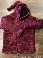 Photo of handmade wool coat in shades of red and maroon with hood, fleece lining, zipper closure, and drawstring hem.