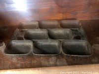 Heavy cast iron gem pan with 9 rectangular baking compartments arranged in three rows.