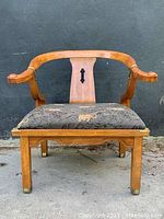 Front view of wooden Ming style chair with upholstered black fabric seat featuring leopard pattern, curved backrest and armrests