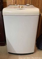 Front view of white portable washing machine with smooth exterior and wheels at base.