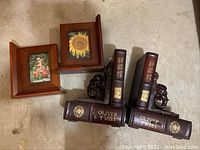 Overview of two sets of bookends: faux classic book bookends with elephant heads and wooden picture frame bookends.