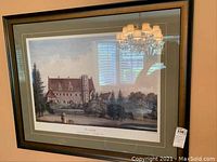 Framed print showing an old manor (Svenstorp) in a natural landscape with dark wooden frame and double matting.