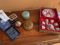 Photo showing the miniature tea set in box and four decorative boxes on wooden table