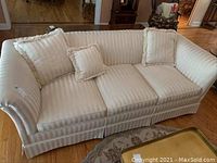 Full view of the fabric sofa showing the upholstery, structure and placement of three pillows.