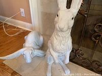 Both rabbit figurines placed on tiled hearth in front of fireplace