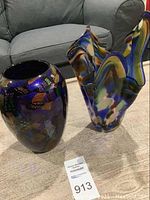 Photo showing both vases on a carpeted floor with a sofa in the background and sale tag visible.