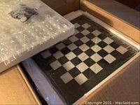 Chess set packaged in box with foam padding includes chessboard and wrapped pieces