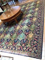 Full view of rectangular area rug with coffee table on top