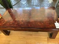 Full view of coffee table showing the brown mottled patterned top and solid wooden legs.