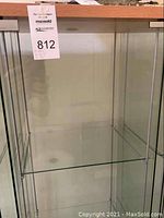 Full view of the Ikea glass display cabinet from the front showing the four glass shelves and clear glass panels.
