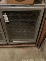 Front view of the Vinotemp wine refrigerator with glass door, showing the exterior and a label on door.