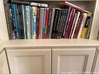 Books on a shelf featuring art, knitting, sculpture, and opera titles.